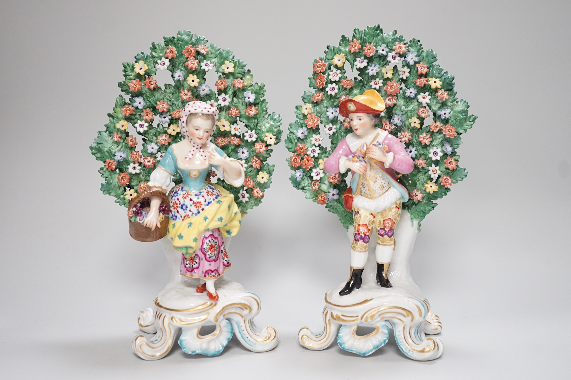 A pair of Derby style bocage figures and three other figures, tallest 26cms high